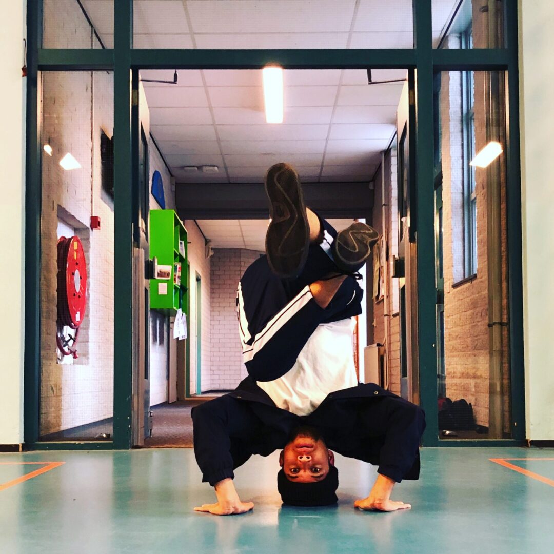 breakdance kinderen headstand hip hop dansmove stoere handstand basisschool leerlingen meester jermaine geeft breakdance les b-boying en b-girling